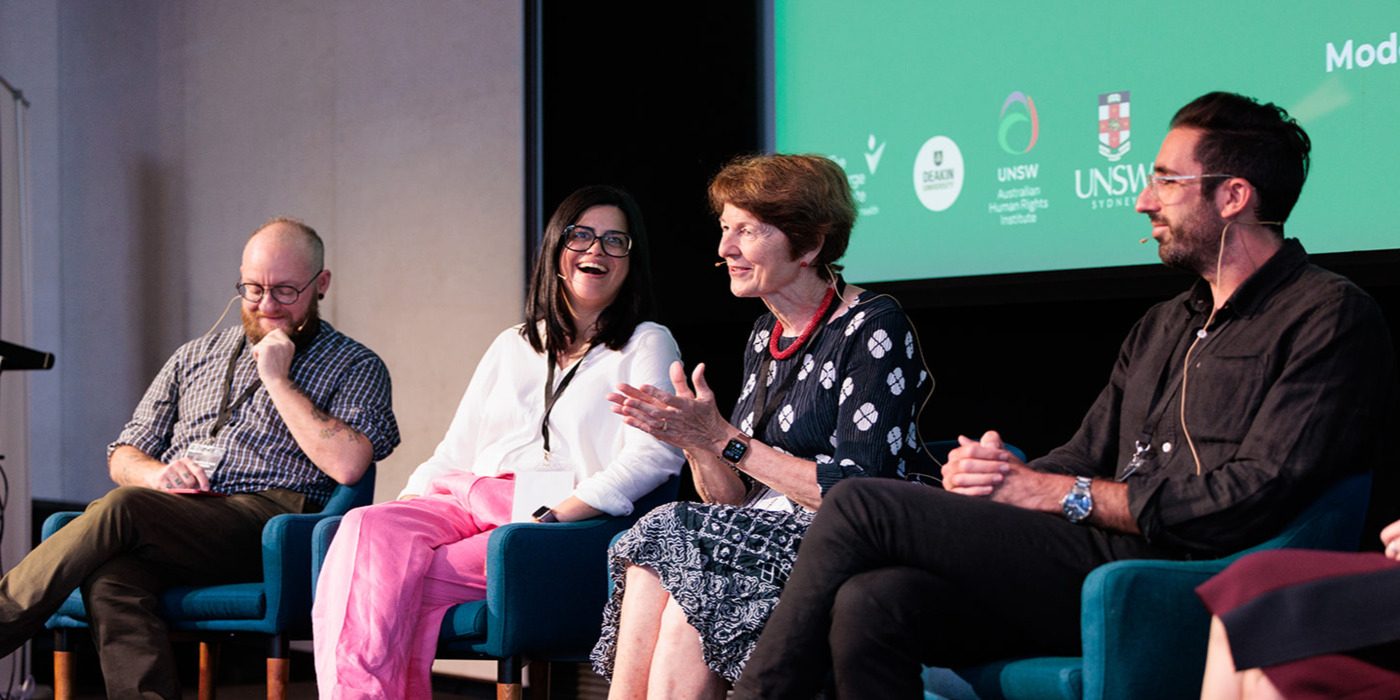 Panel discussion with four people seated, engaged in conversation.